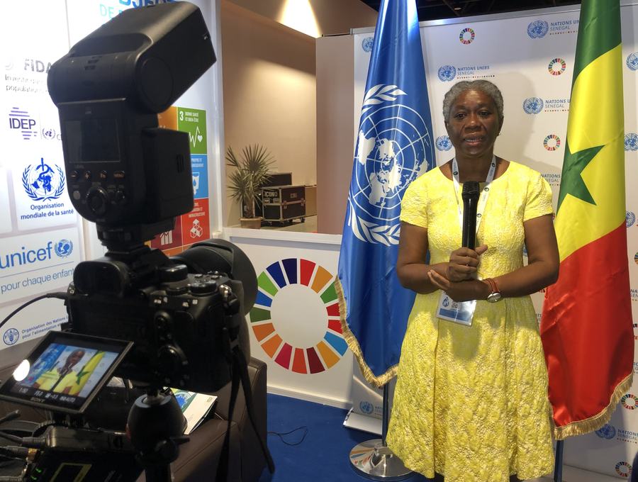 Tournage d'une interview vidéo par l'équipe Waalo Agence, sur un stand institutionnel aux couleurs de l'ONU et du Sénégal