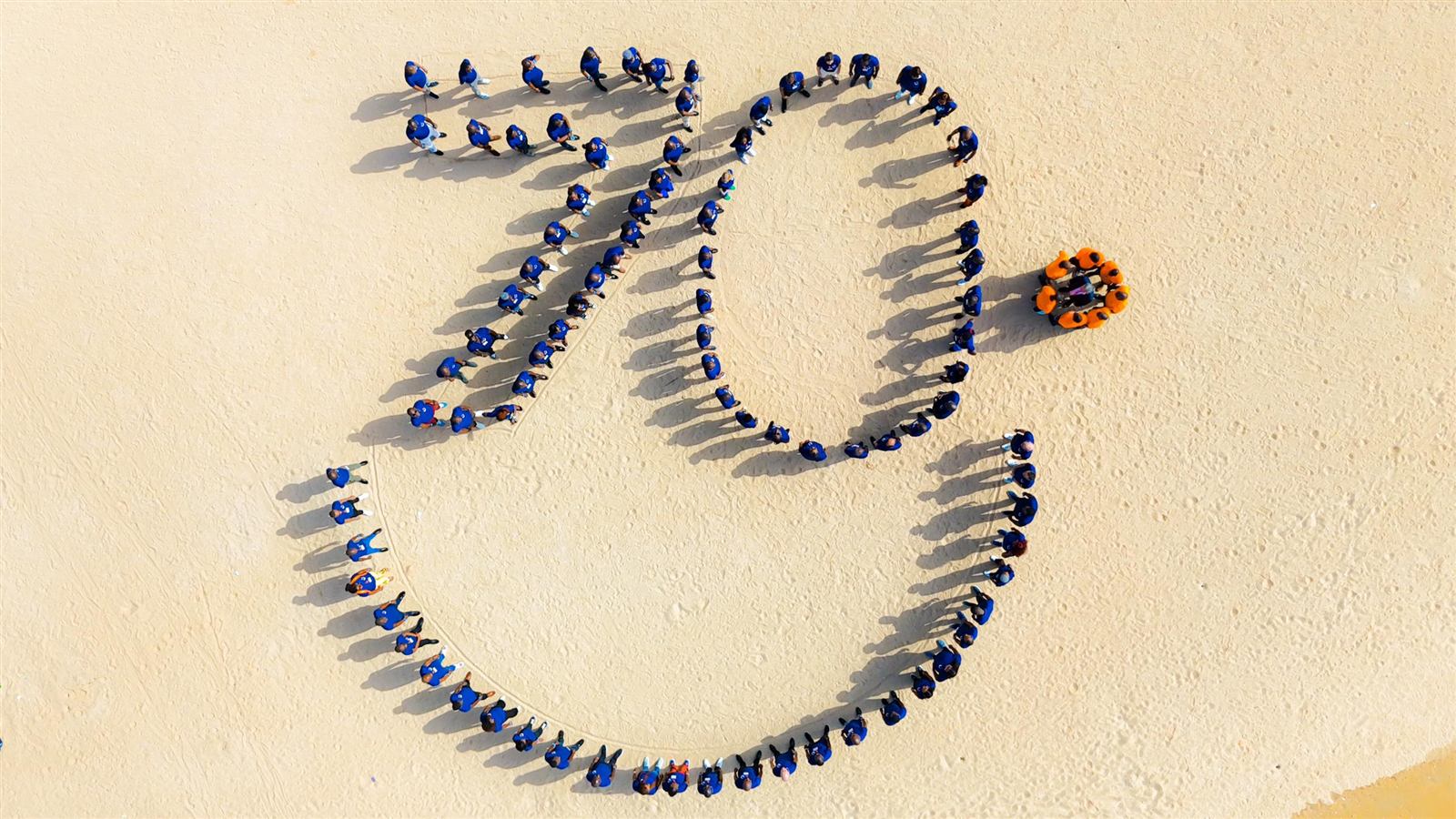 Prise de vue aérienne par drone d'équipes Servier formant un dessin sur une plage